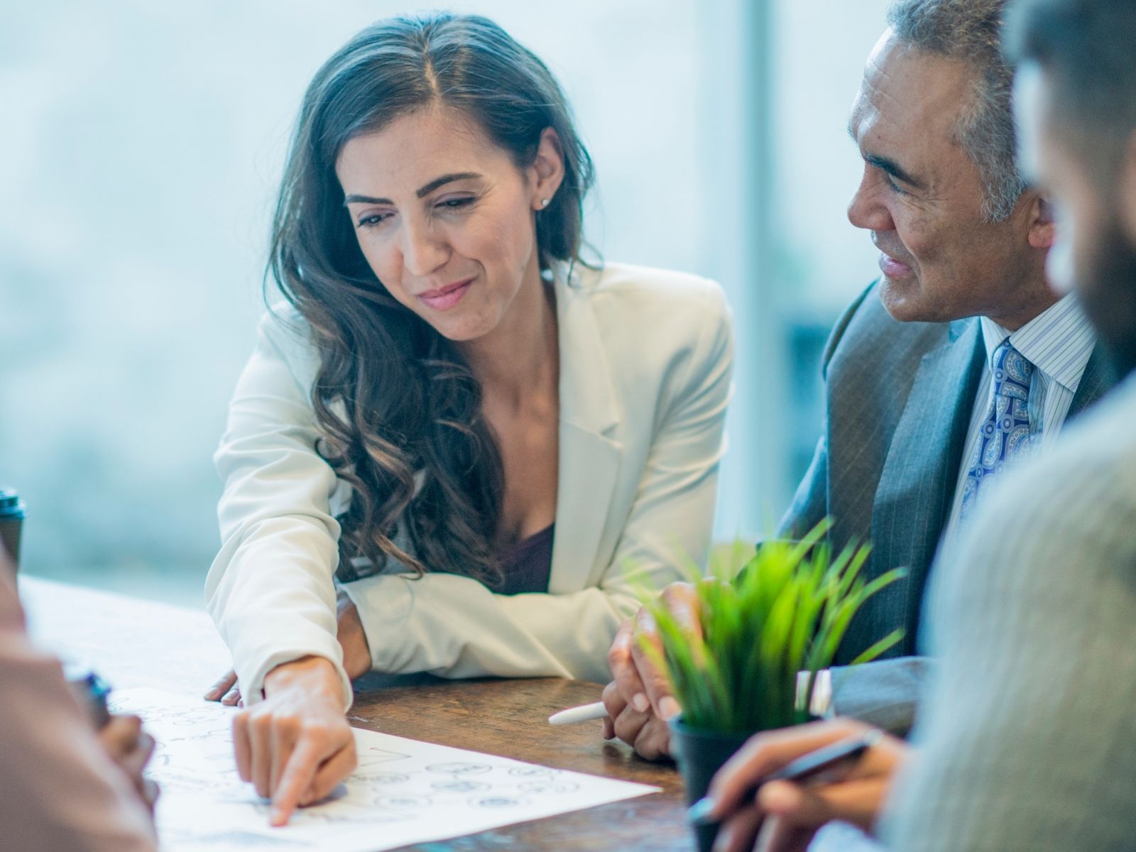 An adviser pointing to a printed plan on the table while a client looks on — the advised, long-term investment process at Global Investments
